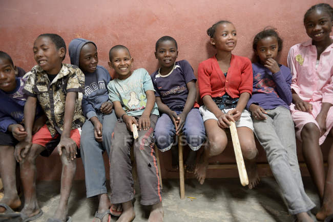 Madagascar, Fianarantsoa, Gli scolari seduti su una panchina di fila — Foto stock
