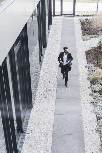 Porträt eines jungen Geschäftsmannes, der auf Fußweg geht — Stockfoto