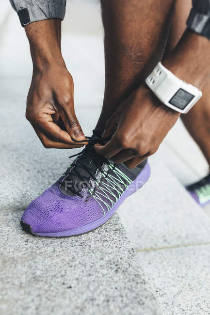 Young Man tying laces on the sport shoe — Stock Photo