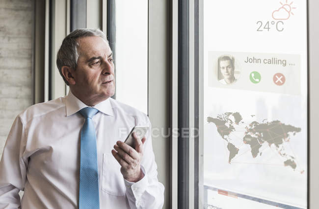 Portrait of senior businessman holding smartphone — Stock Photo