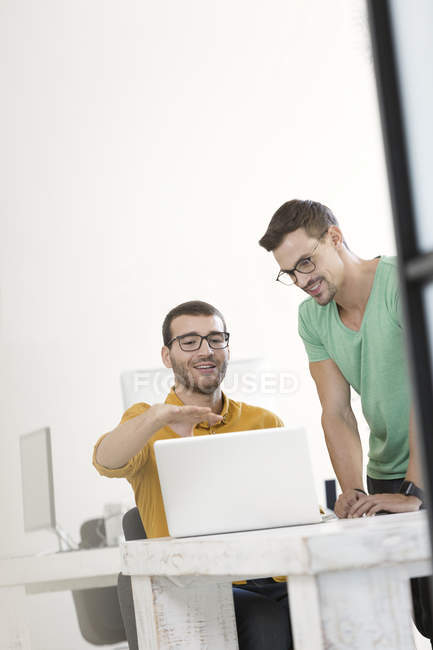Zwei Geschäftsleute, die zusammen im Büro arbeiten und Laptop benutzen — Stockfoto