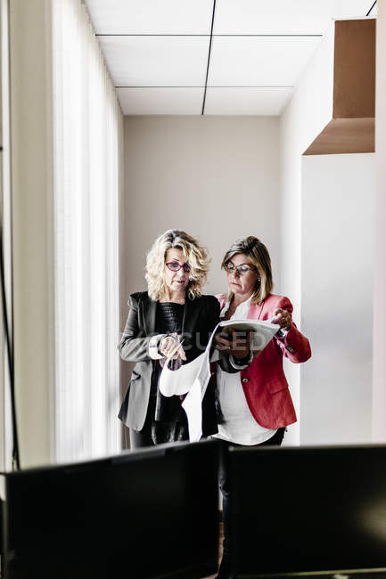 Zwei Geschäftsfrauen arbeiten gemeinsam an Dokument im Amt — Stockfoto