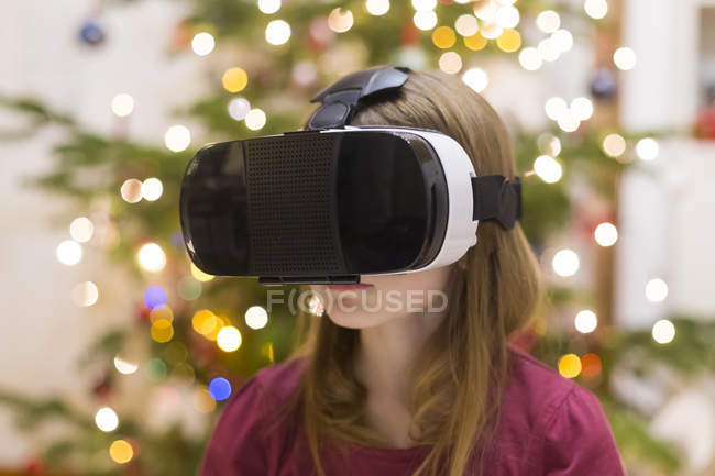 Junges süßes kaukasisches Mädchen mit Virtual-Reality-Brille gegen Tanne — Stockfoto