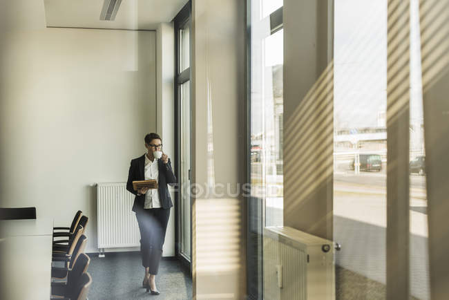 Porträt einer reiferen Geschäftsfrau, die im Büro trinkt — Stockfoto