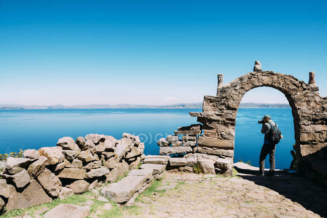 Taquile island, Titicaca lake, Peru. Backpacker taking photos of the Titicaca Lake views — Stock Photo