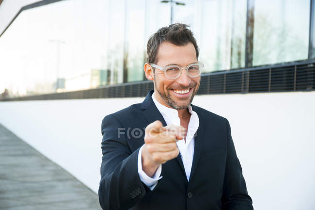 Portrait of confident businessman outdoors pointing with finger — Stock Photo