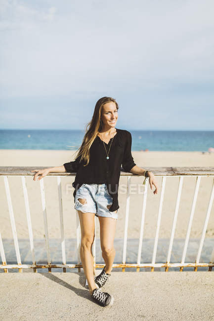 Porträt einer lächelnden jungen Frau am Strand — Stockfoto