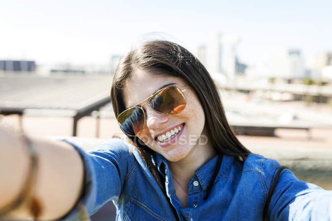 Donna che indossa occhiali da sole prendendo selfie — Foto stock