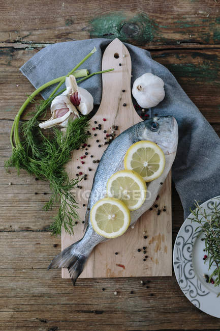 Raw Sea Bream on chopping board — Stock Photo