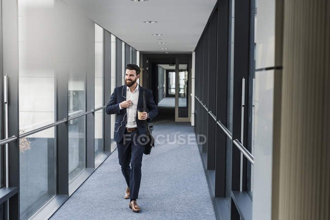 Retrato de un joven hombre de negocios caminando en el pasillo - foto de stock
