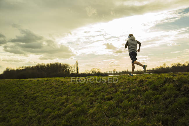 Jovem correndo na estrada do campo — Fotografia de Stock