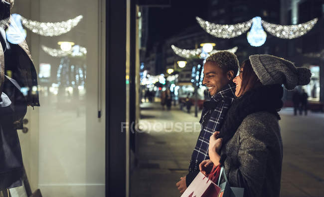 Young couple looking in shop window — Stock Photo