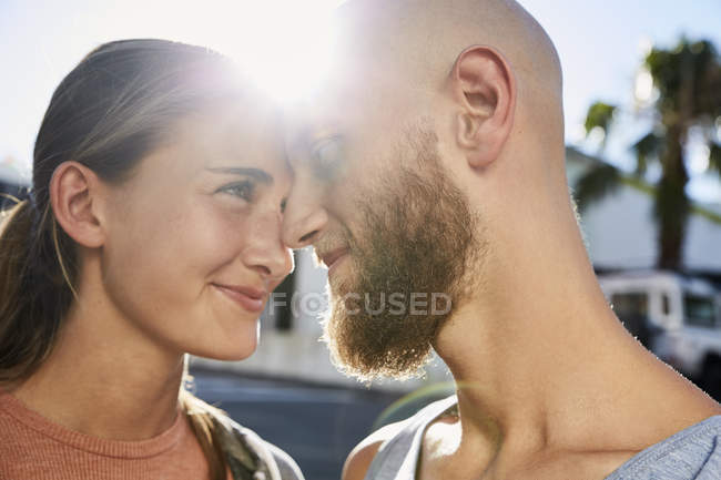 Giovane coppia innamorata faccia a faccia a retroilluminato — Foto stock