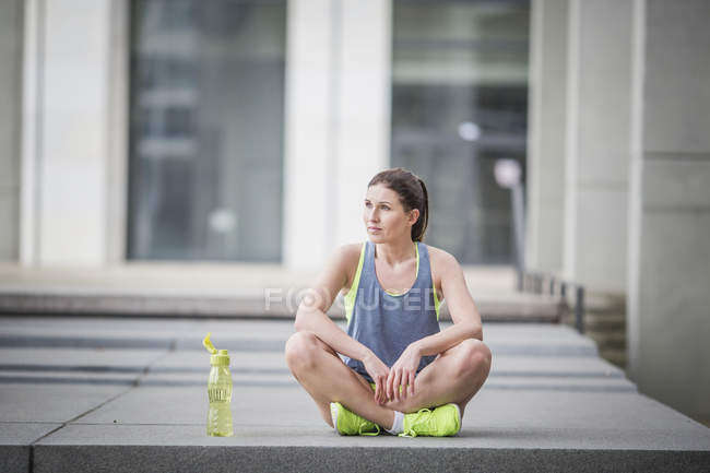 Mulher no esporte desgaste sentado ao ar livre — Fotografia de Stock