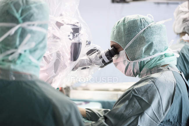 Нейрохірург, переглядаючи мікроскоп під час роботи — стокове фото