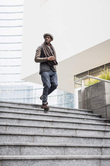 Homem afro-americano elegante descendo as escadas olhando para os lados — Fotografia de Stock