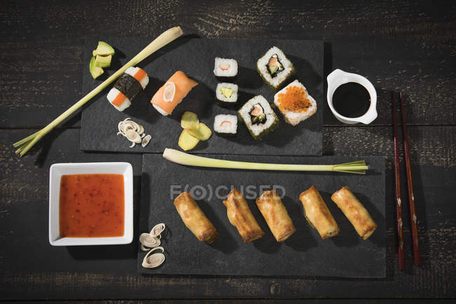 Top view of sushi set on dark background served with soy sauce — Stock Photo