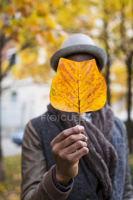Mann mit verdunkeltem Gesicht mit Herbstblatt — Stockfoto