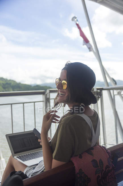 Індонезія, острові Ломбок, щасливі жінка, використовуючи ноутбук на палубі корабля — стокове фото