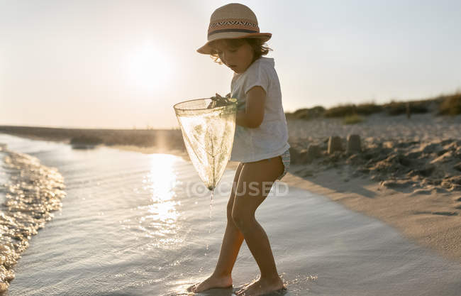 Bambina che gioca con la rete da pesca sulla spiaggia, spiaggia di Son Bou, Isole Baleari, Spagna — Foto stock