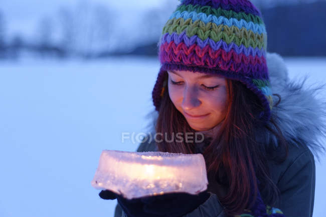 Souriant adolescent fille tenant gâteau en glace avec bougie à l'intérieur — Photo de stock