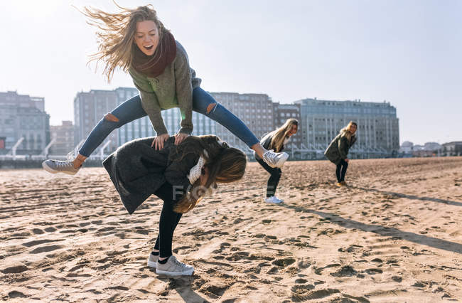 Gijn, Astúrias, Espanha, mulheres jovens se divertindo na praia de areia na cidade — Fotografia de Stock