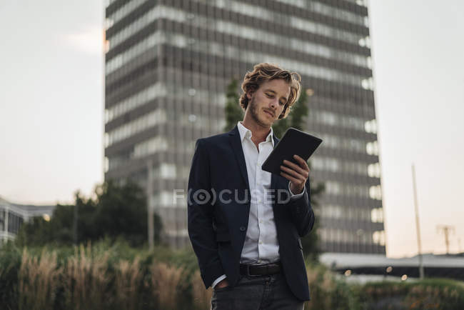 Geschäftsmann steht im Freien und nutzt Tablet — Stockfoto