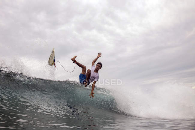 Indonesia, Java, man surfing on waves in ocean — Stock Photo