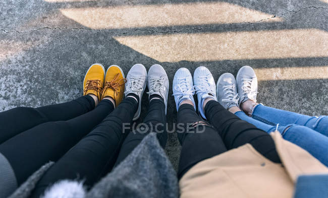 Ноги четырех молодых женщин на асфальте — стоковое фото