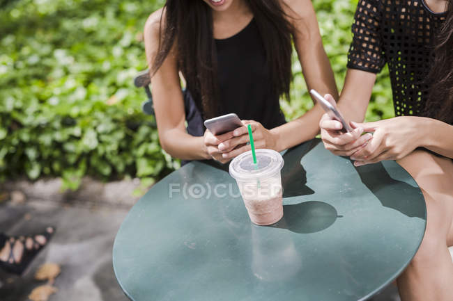 Twin sisters using cell phones — Stock Photo