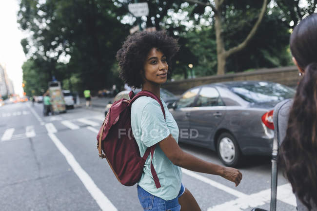Giovane donna afro-americana attraente che attraversa la strada in città — Foto stock