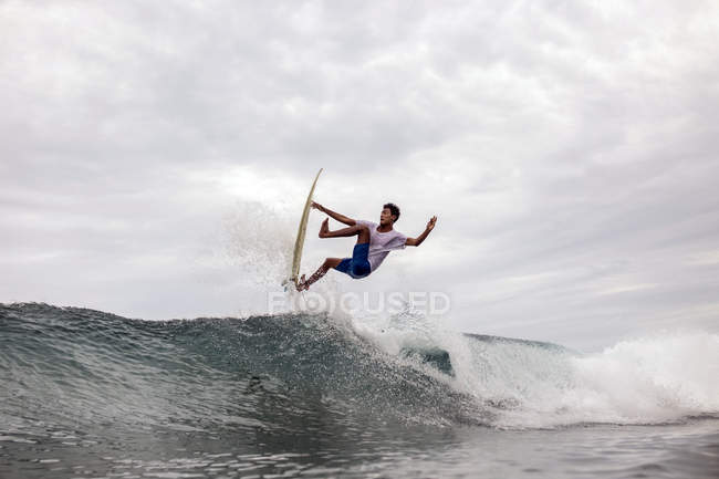 Indonesia, Java, man surfing on waves in ocean — Stock Photo