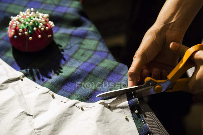 Gros plan de tissu de coupe femme avec ciseaux — Photo de stock