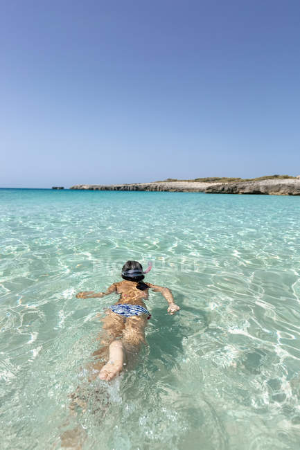 Spain, Menorca, Talaier Beach, girl snorkeling in turquoise water — Stock Photo