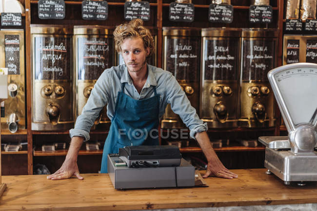 Porträt eines Kaffeerösters, der im Geschäft am Tresen steht — Stockfoto