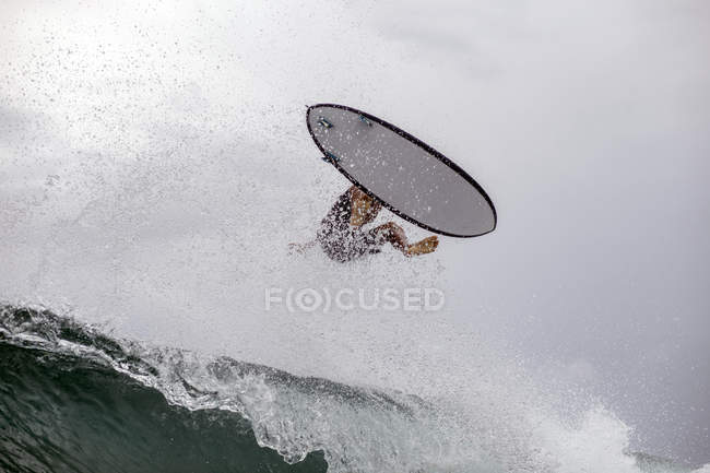 Indonésia, Java, homem surfando em ondas no oceano — Fotografia de Stock