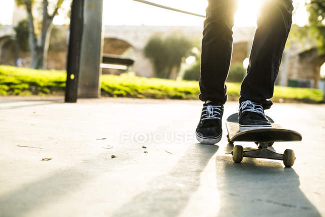 Skater boy iriding skateboard vista bassa sezione sotto il sole — Foto stock