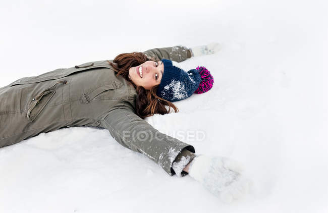 Asturias, España, joven y hermosa mujer tumbada en la nieve - foto de stock