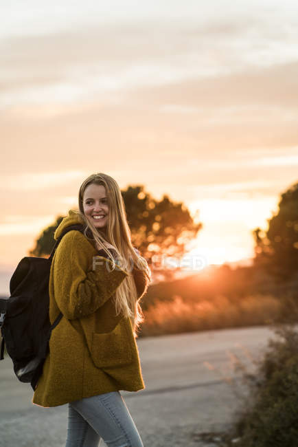 Mulher andando na natureza ao pôr do sol — Fotografia de Stock
