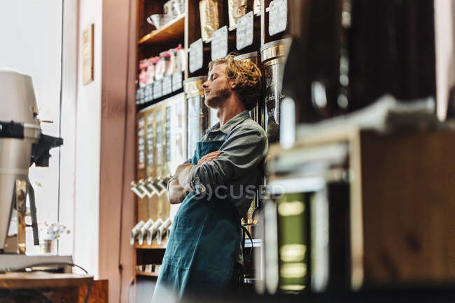 Tired coffee roaster leaning in shop — Stock Photo