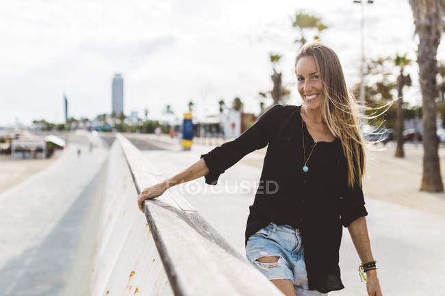 Ritratto di giovane donna felice in piedi sul lungomare — Foto stock