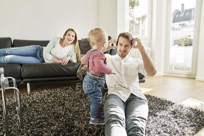 Pais com bebê menina na sala de estar — Fotografia de Stock