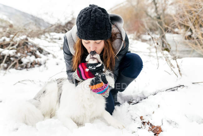 Леон, Іспанія, молодий красивою жінкою даючи поцілувати її собака на снігу — стокове фото