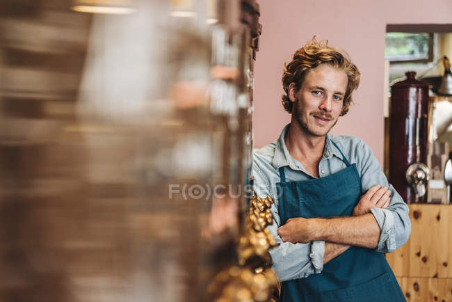 Porträt eines selbstbewussten Kaffeerösters, der mit verschränkten Armen im Geschäft steht — Stockfoto