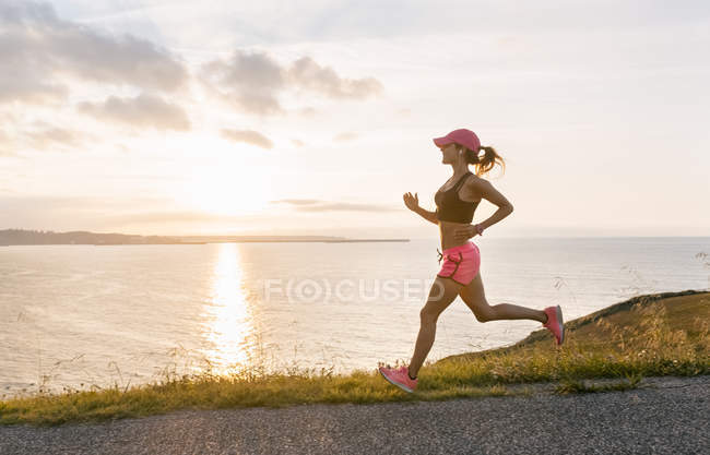 Женщина бежит на морском побережье — стоковое фото