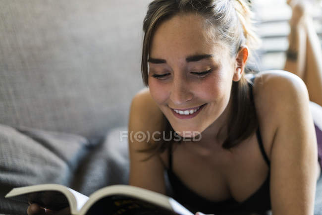 Young woman reading a book at home — Stock Photo