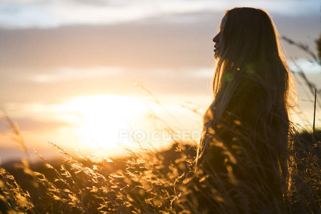 Frau steht bei Sonnenuntergang in der Natur — Stockfoto