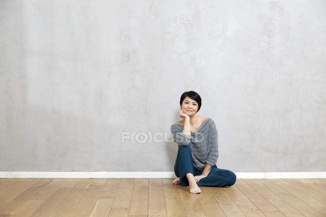 Retrato de mujer sentada en suelo de madera - foto de stock
