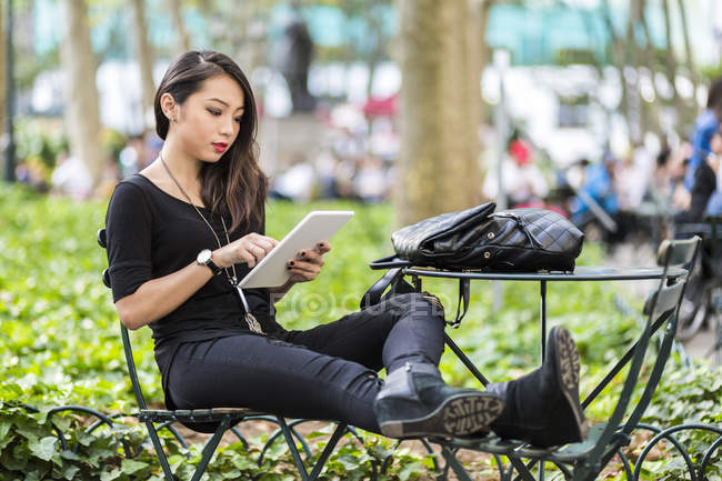 Portrait of young woman using tablet in park — Stock Photo