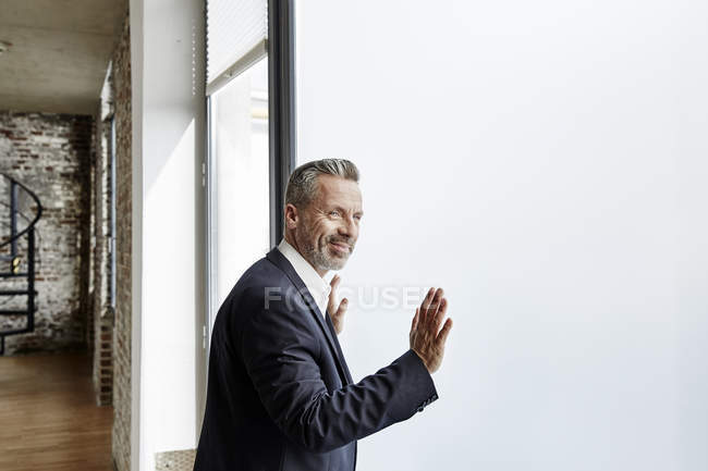 Бизнесмен, стоящий у окна — стоковое фото